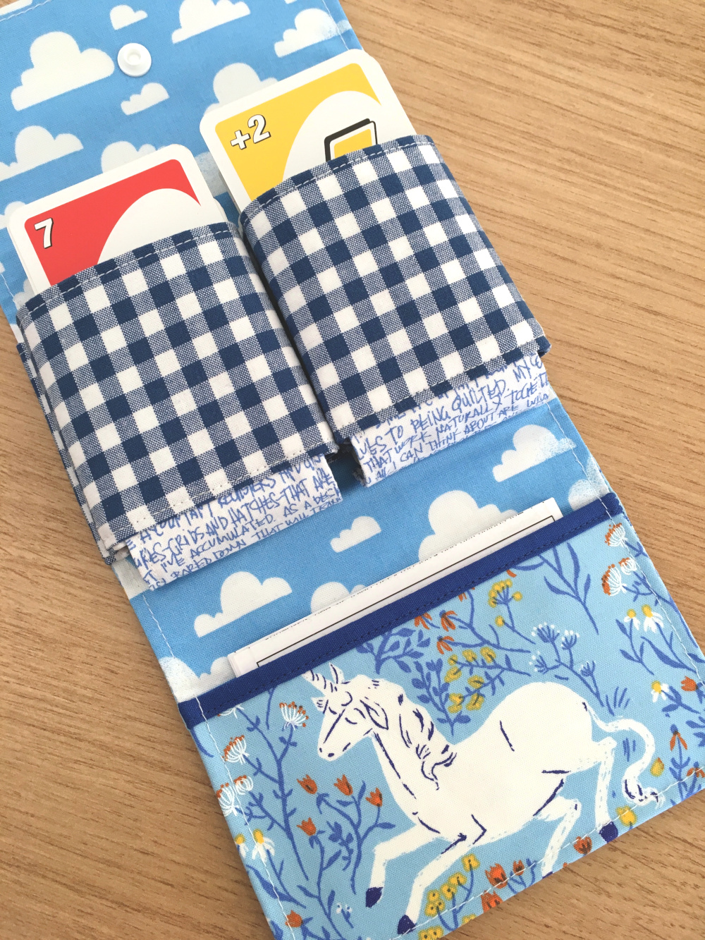 Aufgeklapptes Spielkarten-Etui aus blauen Stoffen, befüllt mit einem UNO-Kartenspiel