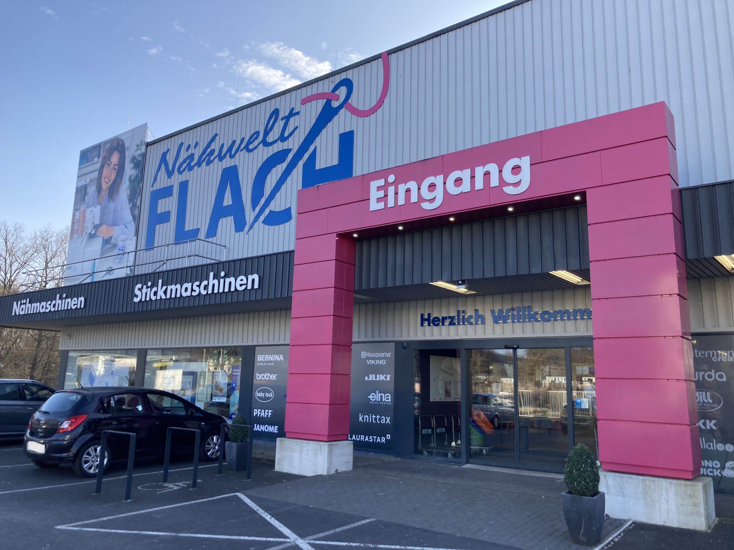 Parkplatz und Eingangstür der Nähwelt Flach in Kleinostheim
